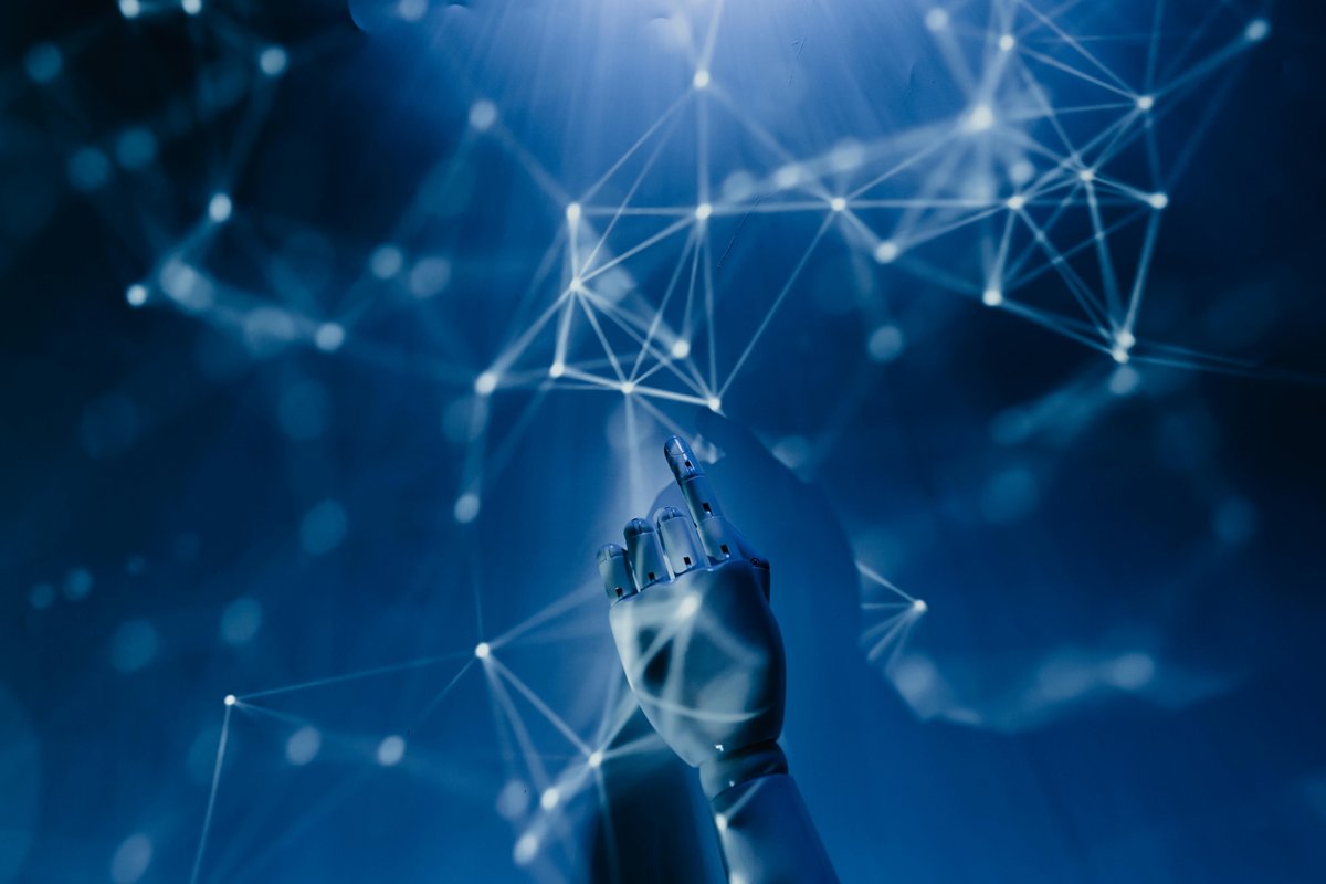 A robotic hand reaching toward a network of connected nodes — the foundations of modern AI platforms