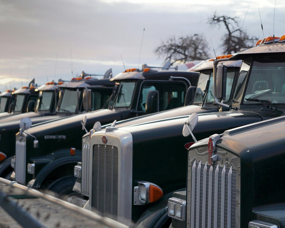 A row of heavy trucks at dawn — AI optimising every mile of the fleet