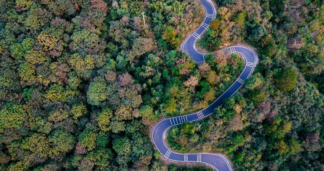 Aerial view of a winding road through forest — a roadmap from pilot to production